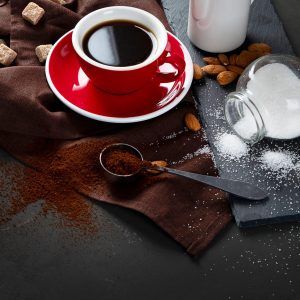 Red coffee cup and beans on dark  table. Top view with copy space